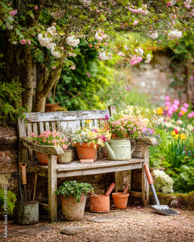 Wooden garden bench surrounded by colorful blooming spring flowers and lush potted plants