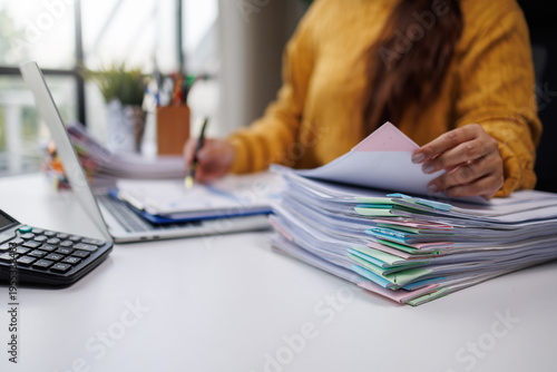 Bilde på lerret A close-up view of a woman's hands organizing colorful folders and papers on her desk, alongside a laptop, demonstrating effective workspace management