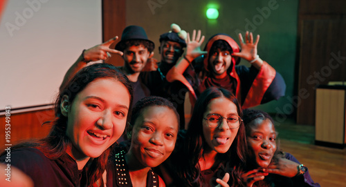 Indian young adult gen z male man female look camera take selfie photos have fun joy hall stage place. Happy teen girl boy group team staring cam do funny pose record video spend day enjoy break time