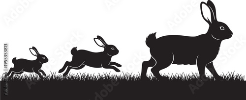 Silhouette of a family of rabbits running through the grass