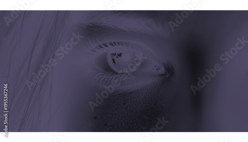 Extreme close-up photograph captures a human eye reflecting light under a dark purple overlay filter.