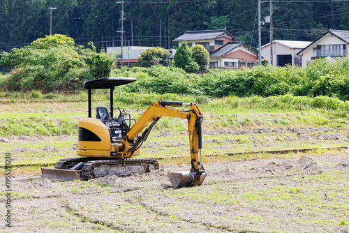 畑を耕す小型油圧ショベル