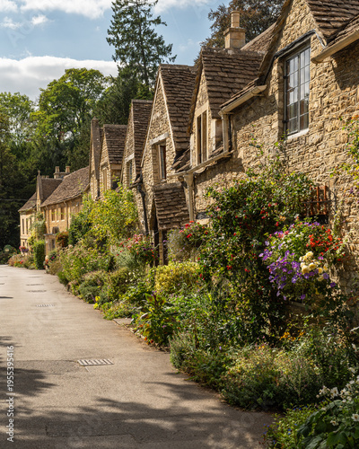 Beautiful flower-lined street with historic stone cottages in the heart of Castle Combe, Cotswolds, England