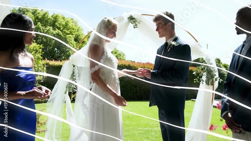 Bride and groom exchanging rings on wooden deck wedding, bridesmaid passing ring, sealing vows