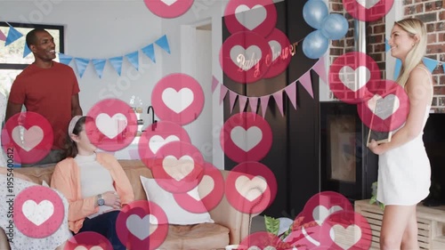 Vertical video: Holding board host in white dress leading baby shower game at home, hearts floating