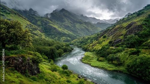 Serene Landscape of Lush Green Mountains and a Flowing River under Cloudy Sky in a Peaceful Valley Scene Ideal for Nature Lovers and Outdoor Enthusiasts