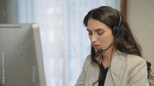 Professional female customer service representative wearing headset assisting clients in office environment
