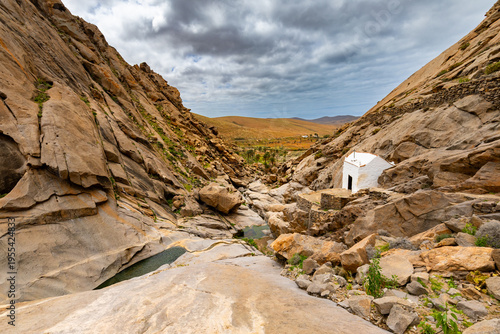 Vast landscape of a rocky ravine at the bottom of a river (Barranco de las Penitas) on the Canary island of Fuerteventura, background or wallpaper for your project 