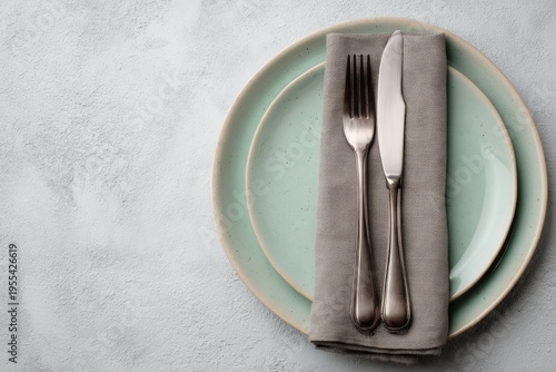 Elegant Table Setting with Plates, Silverware, and Napkin.