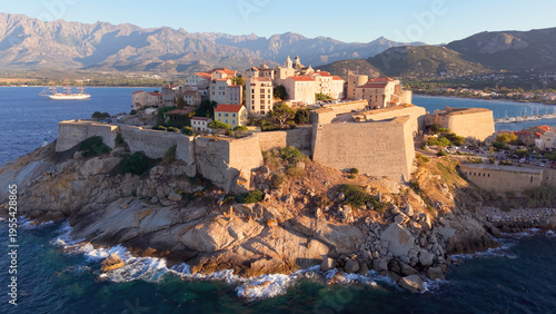Aerial view of calvi citadel at sunrise with serene waters. Fortress with marina. Corsica. France