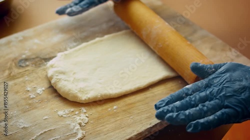 Dough being rolled flat with rolling pin