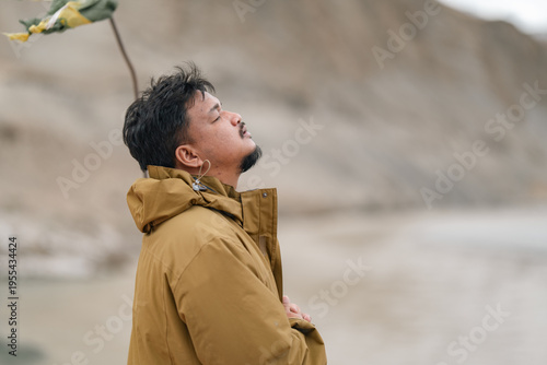 Man in brown jacket stands ...