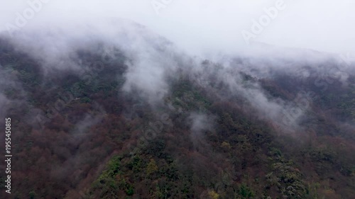 Aerial View of Misty Forest Covered Hills with Moving Clouds