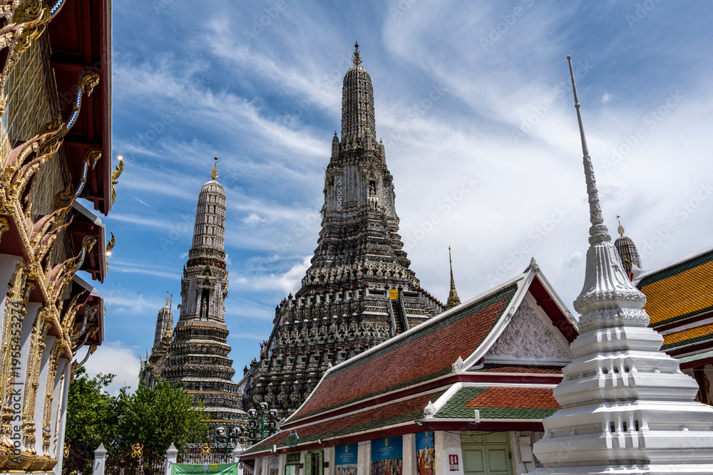 Fototapeta premium Thais in traditional costumes relax at the Temple of Dawn in Bangkok on a sunny day.