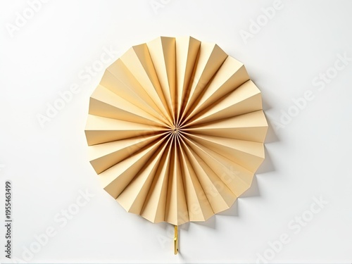 A paper fan hangs on a white wall, a simple decorative element