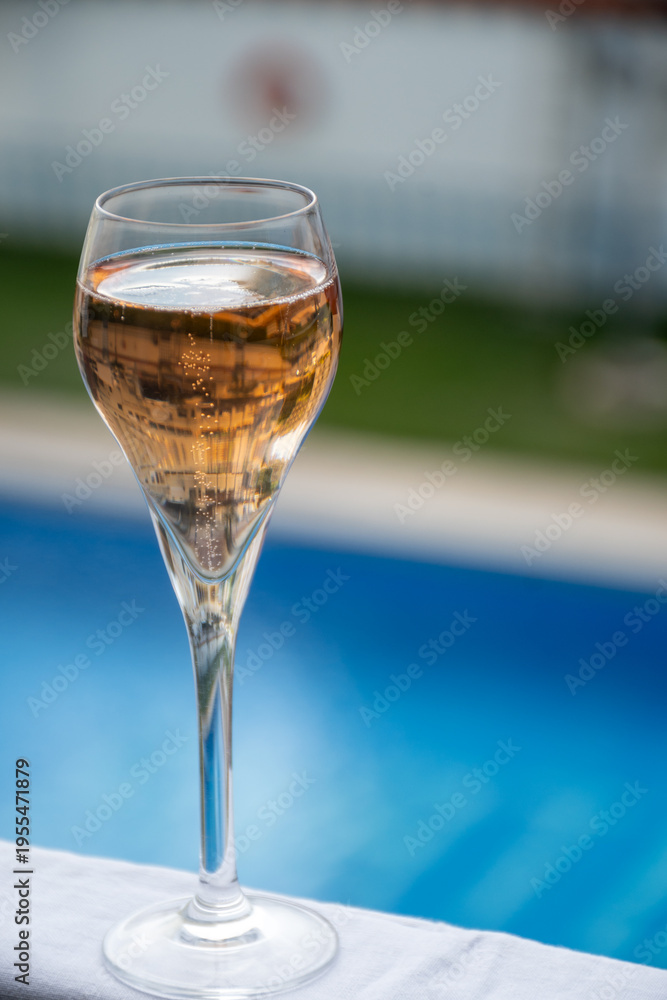 Fototapeta premium Drinking of Champagne or cava sparkling wine at holiday resort on poolside on winter sun vacation on Tenerife, Canary Islands travel destination, Spain