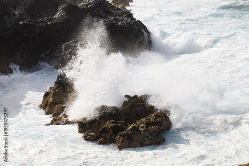 The waves crash powerfully against the rugged coastline of a North Atlantic island.