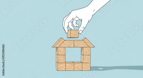 Hand building a house with wooden blocks on a blue background symbolizing construction and development