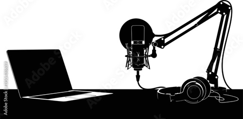 Silhouette of podcast recording setup with microphone, headphones and laptop on desk, content creation concept.