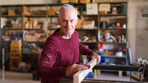Quadro em tela Senior man sanding wood plank creating carpentry craft