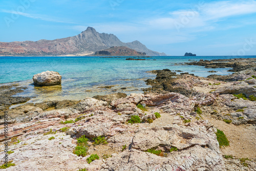 Scenic landscape of the Mediterranean sea on Crete, Greece. Rocks, mountains in the background and blue, clear sky.	