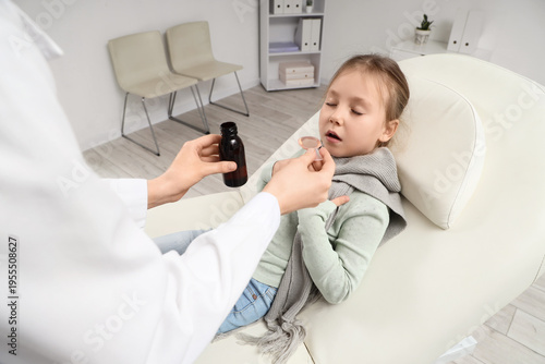 Doctor giving cough syrup t...