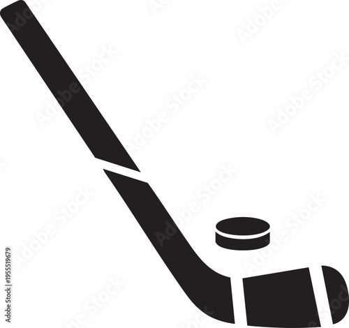 Hockey player swings stick to hit puck on ice rink surface