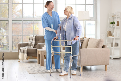 Caregiver and senior woman with walker in nursing home