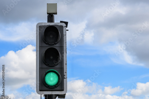 Green traffic light against blue sky go signal UK road