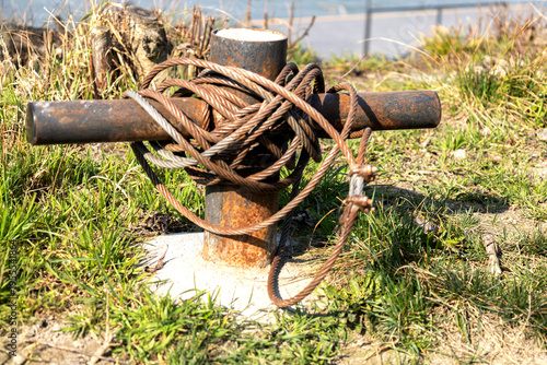 фотографія Close-up of industrial steel wire rope wrapped around a rusty mooring post