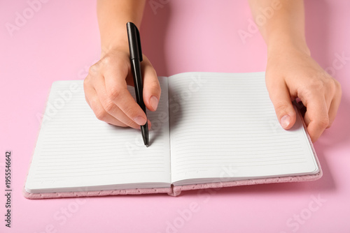 Female hands writing in not...
