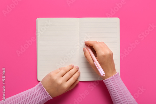 Female hands writing in not...