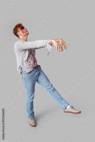 Scary zombie man on grey ba...