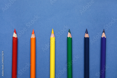 Colorful pencils on blue ba...