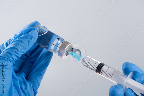 Photos Hand in glove preparing liquid vaccine for injection