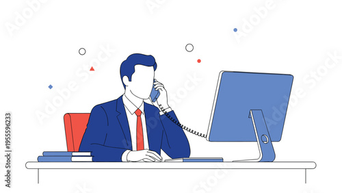 Professional businessman in a blue suit sits at his office desk talking on a wired telephone while working at his computer.