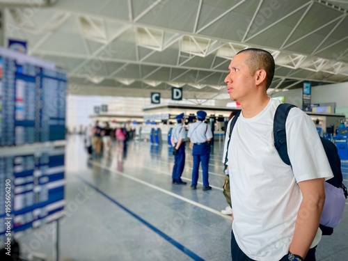 A traveler checking flight schedules at a modern airport terminal.