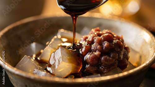 あんみつに黒蜜をかける、美味しそうな和菓子のクローズアップ