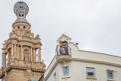 The figure of a cooper high up on the historic Chandos pub near Trafalgar Square in London, with the tower of the London Coliseum behind.