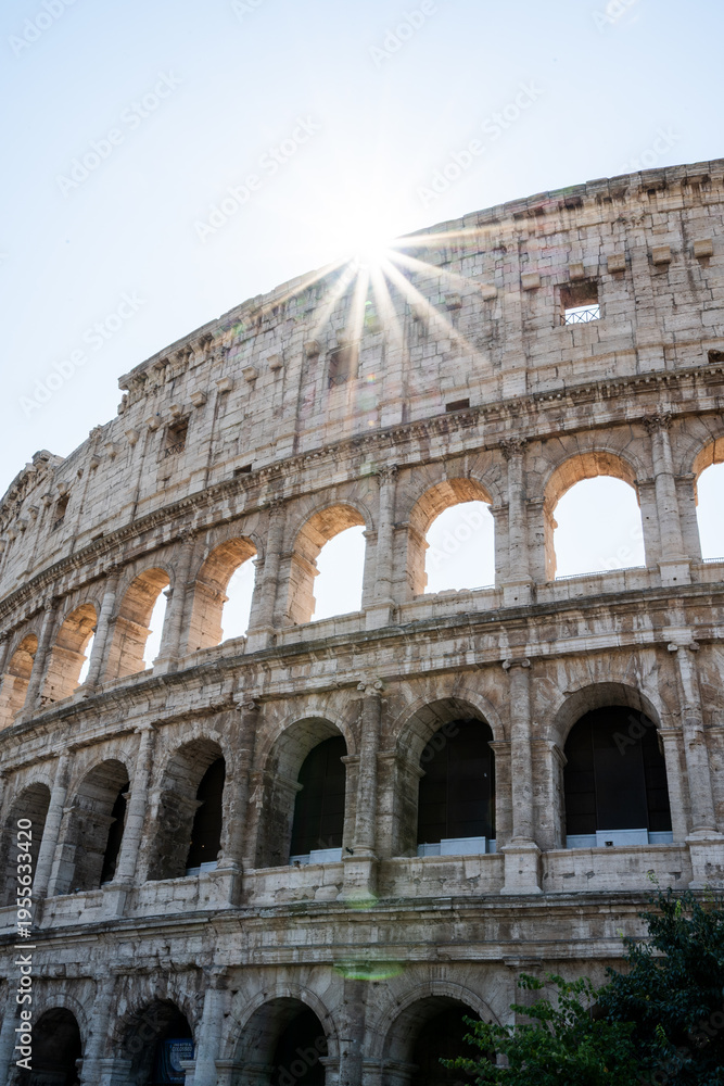 Obraz premium Sunlight Shining Through the Arches of the Ancient Coliseum in Rome During a Clear Day