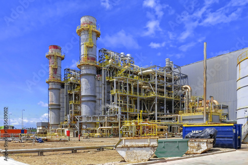 Bilde på lerret A wide-angle view of a complex industrial power plant featuring tall exhaust chimneys, intricate pipe systems, and steel framework structures