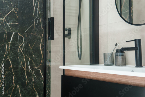 Photos Luxury bathroom interior with marble wall tile and modern black faucet