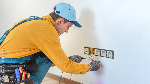 Electrical installation. An electrician during placing the test leads of multimeter across the electrical wires he want to measure.