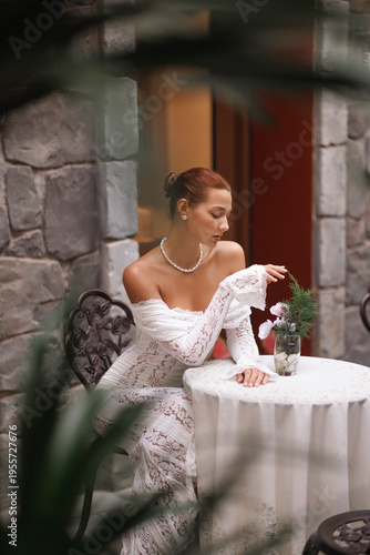 Elegant Woman in Lace Dress Relaxing at Cozy Outdoor Stone Terrace