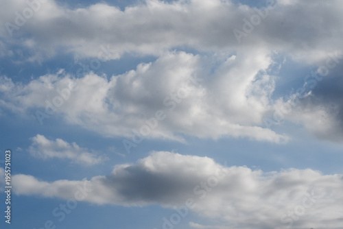 Beautiful blue sky with fluffy-looking white clouds scattered in clusters.