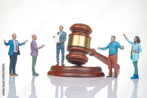 Miniature people gather around gavel in court scene showing legal proceedings and discussions about justice and law
