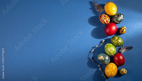 Colorful decorated Easter eggs with feathers on blue background