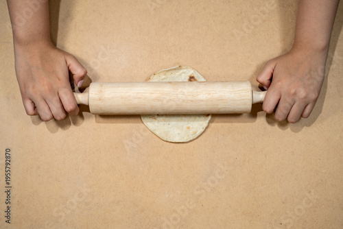 Obraz na plátně Hands using rolling pin to flatten dough on kitchen surface
