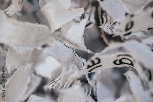 Bild auf Leinwand Close-up view of shredded paper pieces with visible text fragments, showcasing a