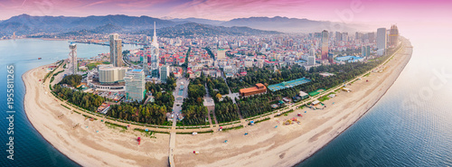Batumi city and Black Sea beach with mountains under a pink sky at sunset from above